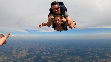 Deux personnes sautant en tandem en parachute au-dessus d'une campagne
