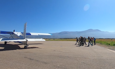 Groupe de personnes marchant vers un avion sur le tarmac.