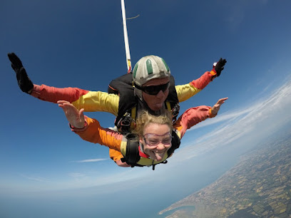 Deux personnes en parachute en tandem avec vue sur la côte.