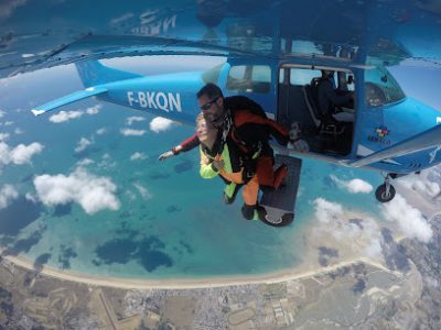 Deux personnes en parachutisme depuis un avion au-dessus de la mer