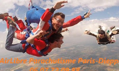 Trois parachutistes en plein ciel avec équipement coloré