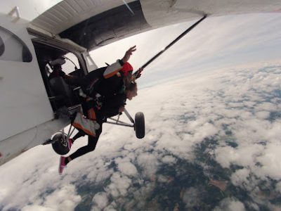Parachutistes sautant d'un avion au-dessus des nuages