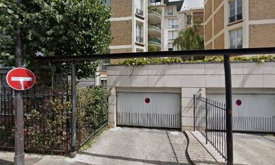 Entrée de garage avec panneau sens interdit, immeubles en arrière-plan.