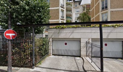 Entrée de garage avec panneau sens interdit, immeubles en arrière-plan.