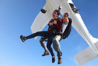 Deux personnes en parachutisme sautant d'un avion en plein ciel