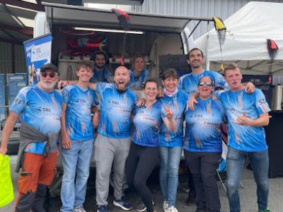 Groupe de personnes en tenue sportive devant un véhicule
