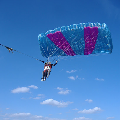 Deux personnes font du parapente sous un ciel bleu