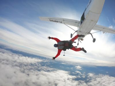 Parachutiste sautant d'un avion au-dessus des nuages.