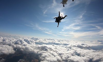 Personnes en parachutisme au-dessus des nuages