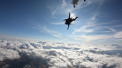 Personnes en parachutisme au-dessus des nuages