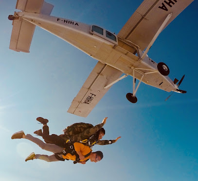 Deux personnes en parachutisme sous un avion en ciel clair