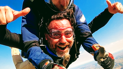 Homme souriant faisant un saut en parachute tandem