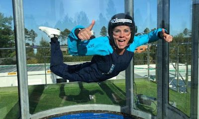 Personne souriante en vol intérieur dans un simulateur
