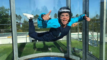 Personne souriante en vol intérieur dans un simulateur