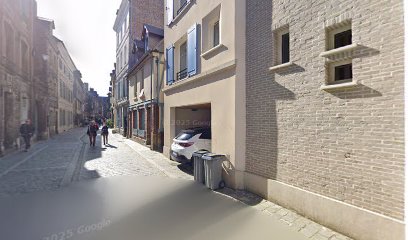 Rue pavée avec maisons en brique et voiture garée à Amiens