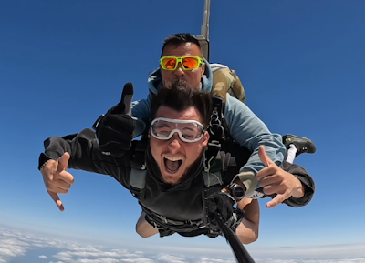 Deux personnes en parachute tandem volant sous un ciel bleu
