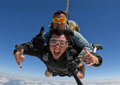 Deux personnes en parachute tandem volant sous un ciel bleu