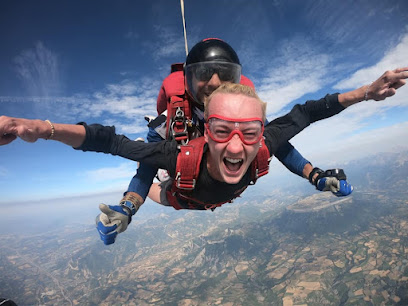 Deux personnes en parachute en plein ciel avec un paysage en dessous.