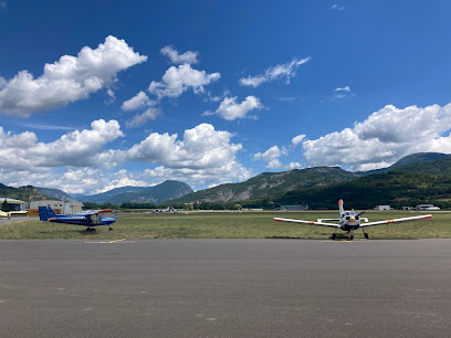 Deux petits avions sur une piste, montagnes en arrière-plan.
