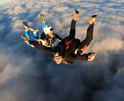 Trois parachutistes en chute libre au-dessus des nuages