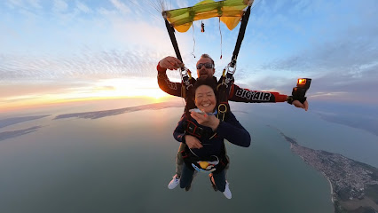 Deux personnes en parachute au-dessus d'un paysage côtier au crépuscule
