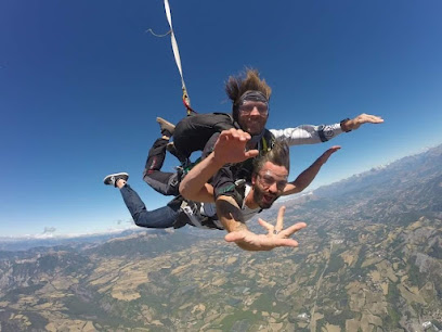 Deux personnes en parachute au-dessus de paysages montagnards.