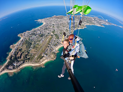 Deux personnes effectuant un saut en parachute au-dessus d'une côte pittoresque