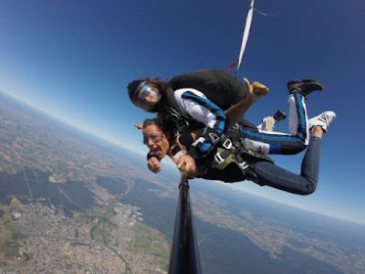 Deux personnes font du parachutisme au-dessus d'un paysage urbain.