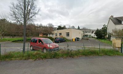 Parking avec voitures devant un bâtiment scolaire