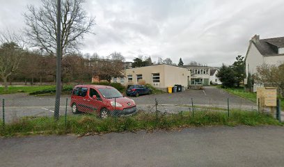 Parking avec voitures devant un bâtiment scolaire