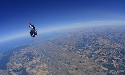 Parachutiste en chute libre survolant un paysage terrestre
