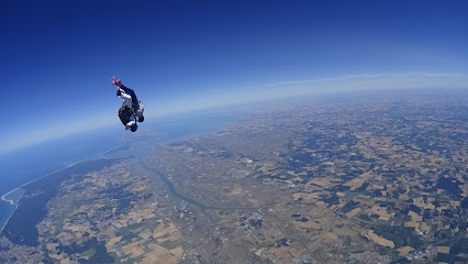 Parachutiste en chute libre survolant un paysage terrestre
