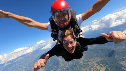 Deux personnes font du parachutisme avec vue sur les montagnes en arrière-plan.