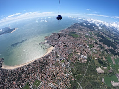 Vue aérienne d'une ville côtière avec parachutiste en tandem
