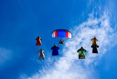 Groupe de parachutistes en combinaison ailée dans le ciel bleu