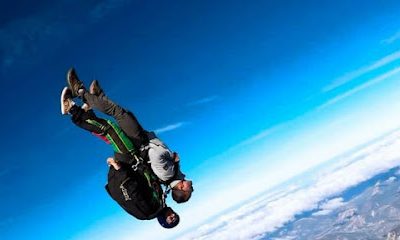 Deux personnes en chute libre sous un ciel bleu.