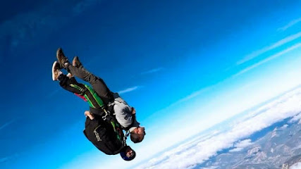 Deux personnes en chute libre sous un ciel bleu.