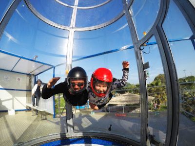 Deux personnes en combinaison volant dans un tunnel de vent.