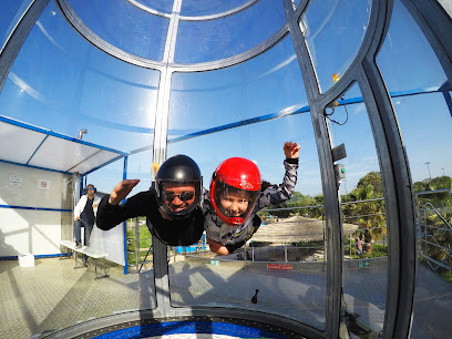 Deux personnes en combinaison volant dans un tunnel de vent.