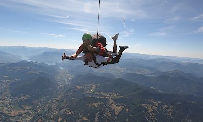 Parachutistes en tandem survolant un paysage montagneux