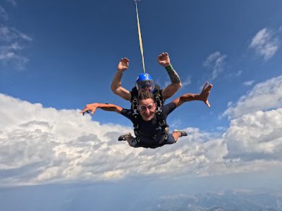 Deux personnes sautant en parachute au-dessus des nuages.