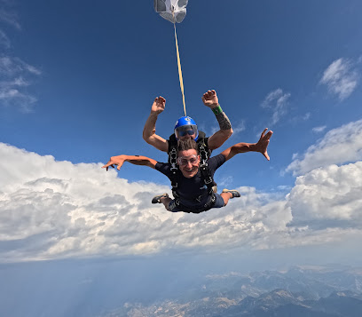 Deux personnes sautant en parachute au-dessus des nuages.