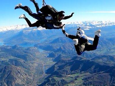 Deux parachutistes en chute libre au-dessus de montagnes.