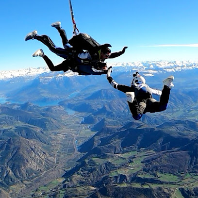 Deux parachutistes en chute libre au-dessus de montagnes.